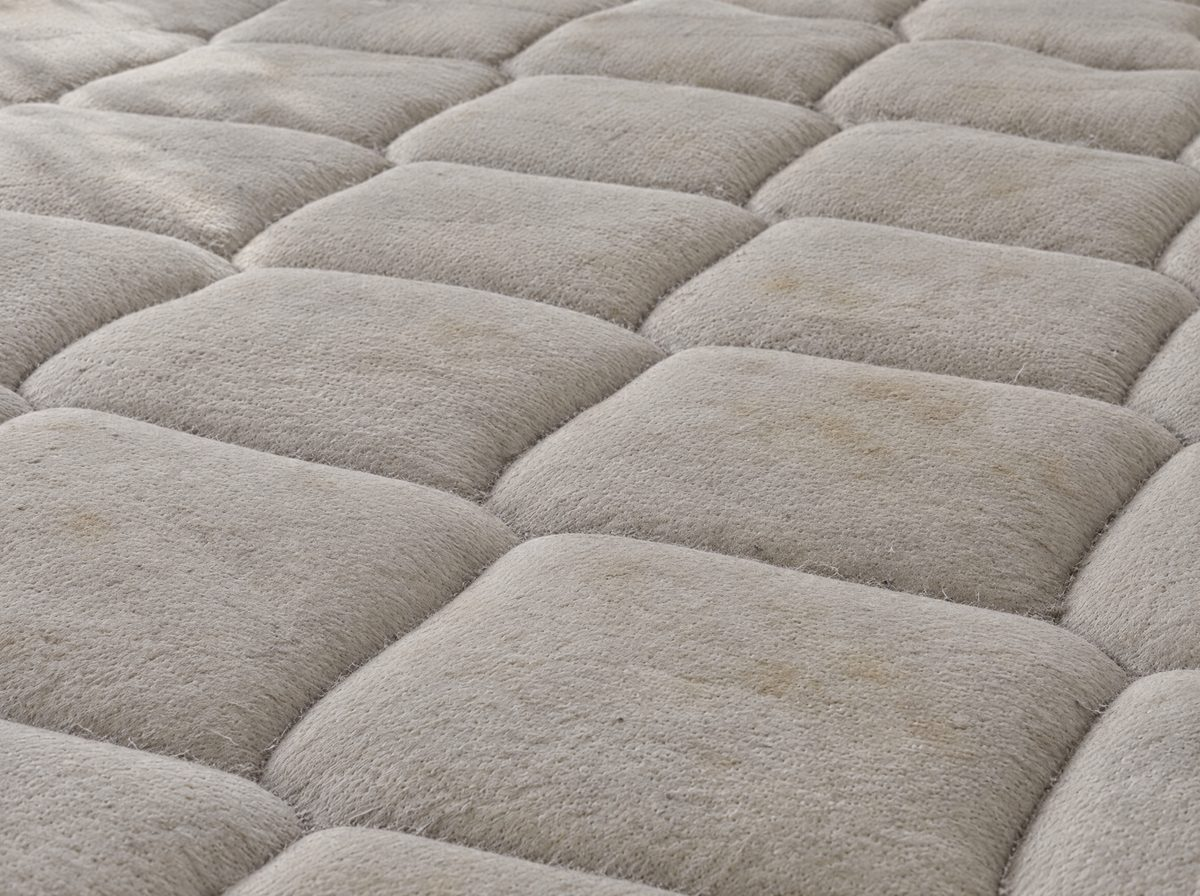 Dull, dusty quilted mattress before extraction